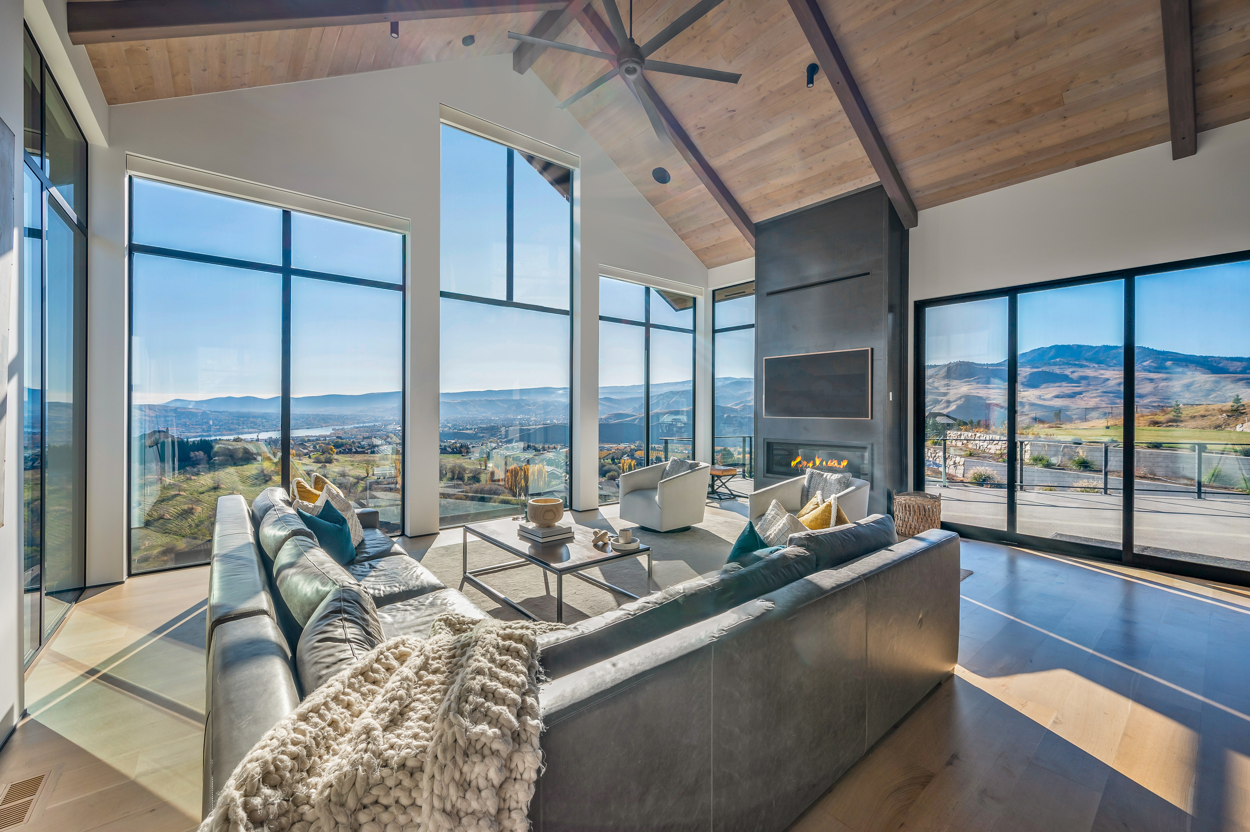 Living room with panoramic aluminum windows showing desert view. 