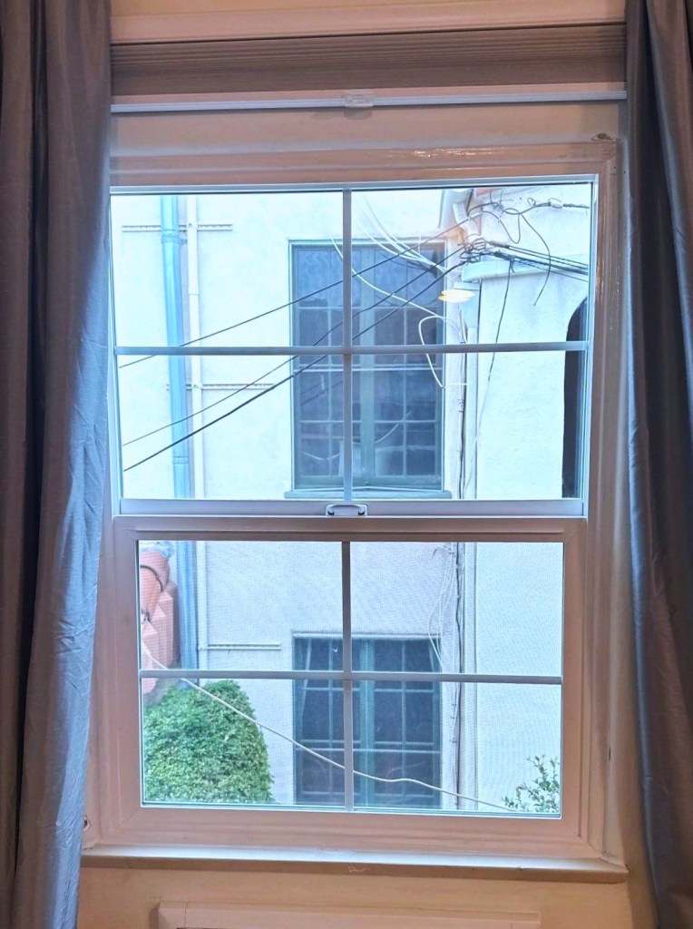 White vertical sliding window with cross pattern grids